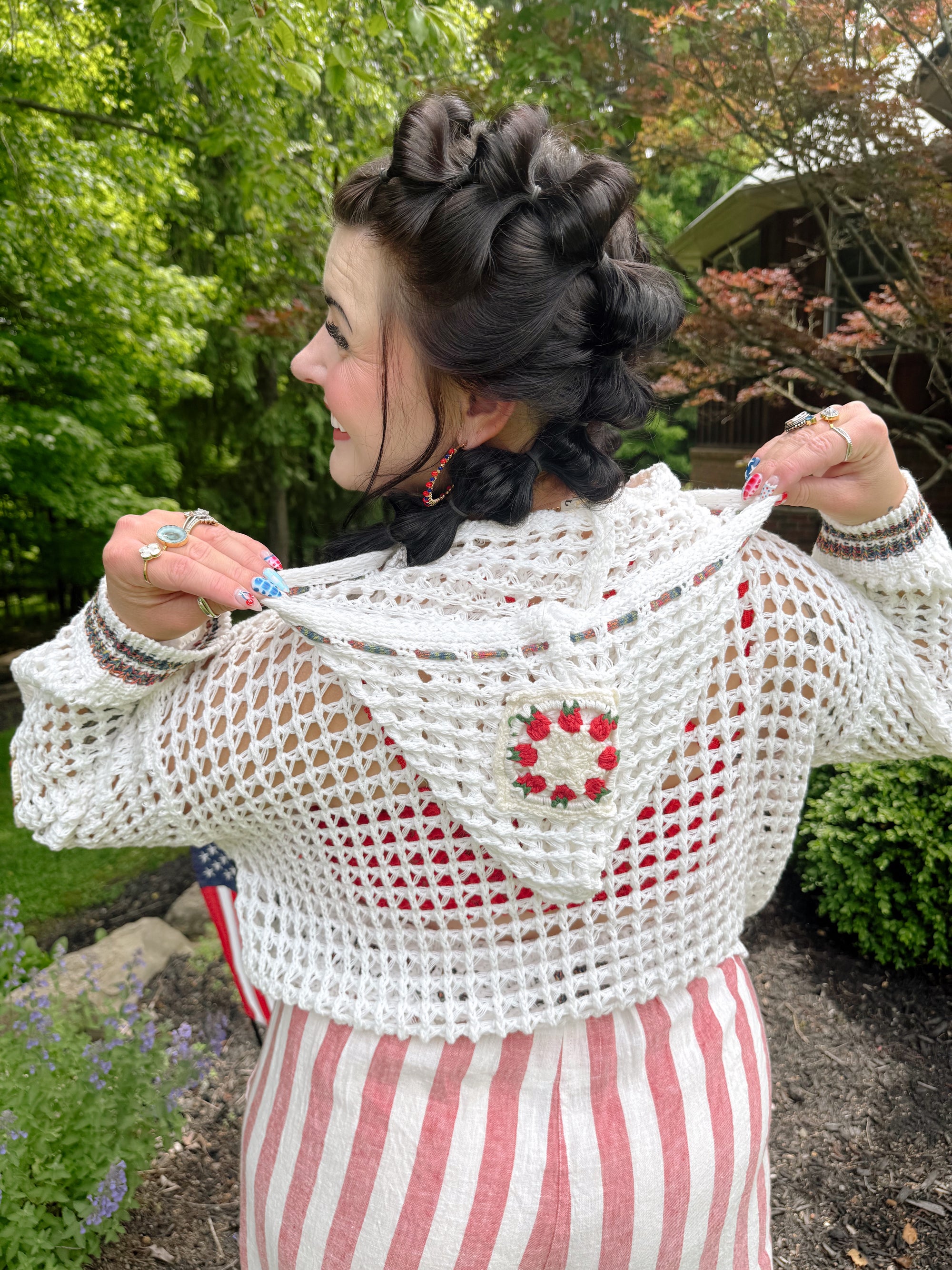Woman wearing a white crochet top with a floral design outdoors